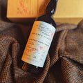 Bouteille de Single Malt Scotch Whisky Highland 12 ans Reserve Casks The Single Malts of Scotland Elixir Distillers sur un tissu de Harris Tweed