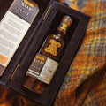 Bouteille de Single Malt Scotch Whisky Ledaig 23 ans Xtra Old Particular Black Series Douglas Laing posée sur une étoffe de Harris Tweed