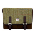 Vue de face de la grande sacoche Harris Tweed® au motif chevron marron-vert montrant le large rabat en laine, les deux lanières de fermeture en cuir végan marron avec boucles métalliques et l'étiquette d'authentification Orb Mark.