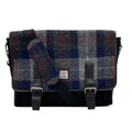 Vue de face de la grande sacoche Harris Tweed® au motif tartan bleu et gris montrant le large rabat en laine, les deux lanières de fermeture en cuir végan noir avec boucles métalliques et l'étiquette d'authentification Orb Mark.