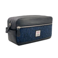 Vue de face de la grande trousse de toilette Harris Tweed® présentant le tissage chevron bleu marine profond et noir avec sa poche zippée extérieure et son étiquette de certification Orb Mark.