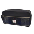 Vue de face de la grande trousse de toilette Harris Tweed® montrant le motif tartan du tweed gris anthracite et bleu marine et l'étiquette d'authenticité Orb Mark.