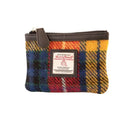 Vue de face du petit porte-monnaie Harris Tweed® au motif tartan jaune, bleu et rouge avec fermeture éclair et bordure en cuir végan marron foncé.