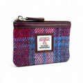 Vue de face du petit porte-monnaie Harris Tweed® rose et bleu avec fermeture éclair et bordure en cuir bordeaux.
