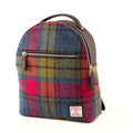 Vue de face du petit sac à dos Harris Tweed® présentant un tartan riche en nuances de rose, rouge, bleu et vert avec poche frontale zippée et l'étiquette d'authentification Orb Mark.