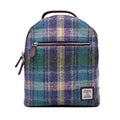 Vue de face du petit sac à dos Harris Tweed® montrant le rabat au motif tartan violet, vert et bleu et l'écusson d'authenticité Orb Mark.