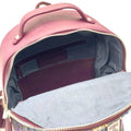 Vue plongeante du compartiment principal ouvert du petit sac à dos Harris Tweed®, révélant la doublure textile et les poches de rangement internes.