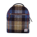 Vue de face du petit sac à dos Harris Tweed® présentant son tartan terreux, bleu, gris et marron, croisé de lignes oranges et son étiquette d'authentification Orb Mark.