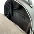 Vue plongeante du compartiment principal ouvert du petit sac à dos Harris Tweed®, révélant la doublure textile et les poches de rangement internes.