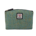 Vue de face de la petite trousse de toilette Harris Tweed® montrant le tissage à chevron bleu-vert en laine artisanale et l'étiquette de certification Orb Mark.