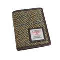 Vue de face du portefeuille deux volets Harris Tweed® avec un motif chevron marron-vert et des touches de bleu et de bronze, bordure en cuir végan marron.