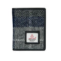 Vue de face du portefeuille deux volets Harris Tweed® avec un motif tartan à carreaux gris et bleu marine, bordure en cuir végan noir.